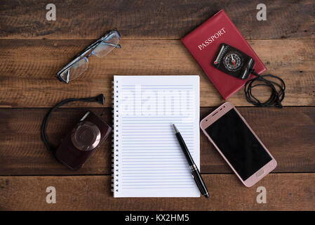 Passeport, ordinateur portable, appareil photo, Boussole sur smartphone et une table en bois. travel concept Banque D'Images
