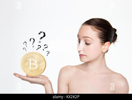 Girl holding bitcoin sur sa main avec des points d'interrogation sur fond blanc Banque D'Images