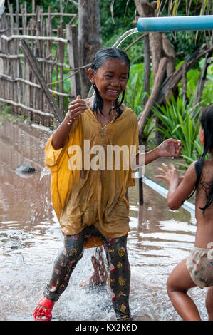 Les enfants cambodgiens au jeu sous la conduite d'eau Banque D'Images