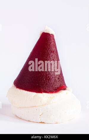 M&S mini Santa hat - base de meringue croustillante garnie de crème vanille et gelée de framboise isolé sur fond blanc Banque D'Images