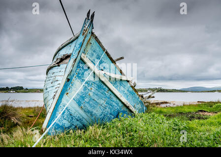 La proue de l'épave d'un vieux bateau de pêche en bois bleu échoué sur la côte près du port de Roundstone à Connemara, Irlande Banque D'Images