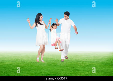 Famille heureuse, Parents Swinging Boy Holding Hands In Park Banque D'Images