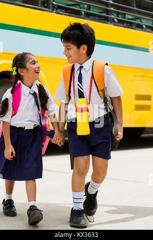 2 Heureux les étudiants de l'école indienne ami mains tenant à marcher ensemble Banque D'Images