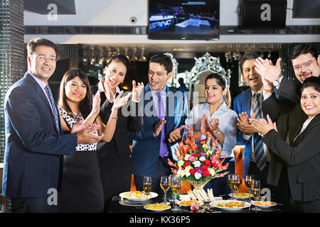 Les gens d'affaires du groupe de collègues applaudir des Mains Mains célébrant In Restaurant Banque D'Images