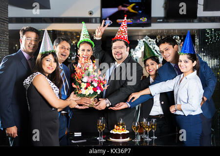 Hommes et de femmes d'affaires du groupe.Partner Anniversaire Party-Hotel Bouquet célébration donnant Banque D'Images