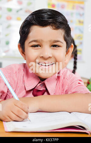 Happy 1 Indian School Enfant Garçon en classe l'étude de l'écriture de l'ordinateur portable Banque D'Images