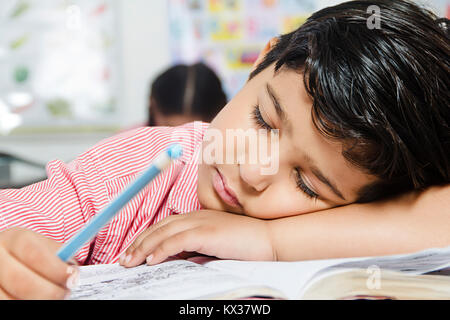 1 petit garçon de l'école indienne de dormir dans l'étude de la paresse en classe Banque D'Images