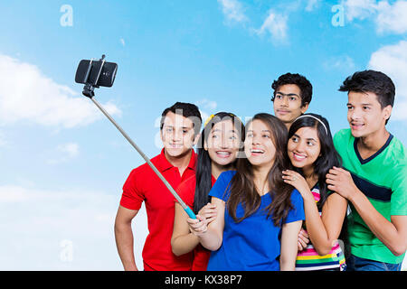 Groupe indien jeunes amis ensemble en tenant Téléphone Selfies Monopod Fun Banque D'Images