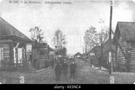 Photographie de la rue Dniaproŭskaja à Žłobin, Biélorussie, prise entre 1901 et 1917. L'image montre une scène urbaine typique du début du XXe siècle avec des chariots tirés par des chevaux et des piétons. Žłobin, située dans la région de Gomel, était un important carrefour ferroviaire durant cette période. Banque D'Images