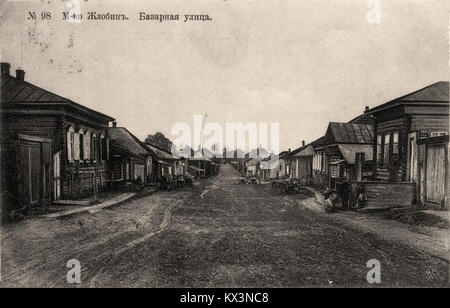 Photographie de la rue Rynkavaja à Žłobin, Biélorussie, prise entre 1901 et 1917. L'image représente une scène urbaine typique du début du XXe siècle avec des chariots tirés par des chevaux et des piétons. Žłobin, située dans la région de Gomel, était un important carrefour ferroviaire durant cette période. Banque D'Images