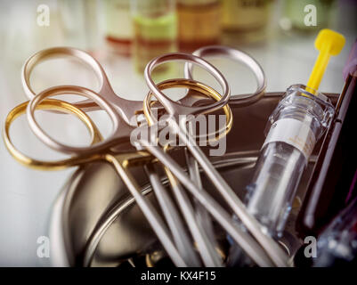 Les ciseaux et les flacons d'échantillons de sang dans un bac sur une table d'un hôpital, conceptual image Banque D'Images