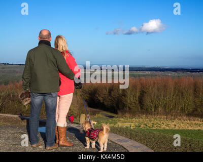 L'homme et la femme avec chien profitant de la vue depuis la colline Old Pale dans Delamere Forest Cheshire, à 176 mètres du point le plus haut de la crête de grès du Cheshire Banque D'Images