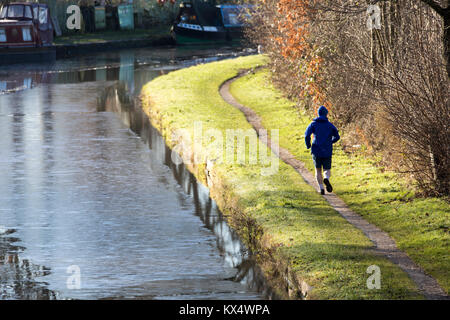 Cheshire, Royaume-Uni Météo. Des températures glaciales la nuit ont laissé une forte frost pour beaucoup au Royaume-Uni. Une personne habillée pour le froid qu'il déroule le long de l'toepath sur le Canal de Bridgewater, Warrington, Cheshire Banque D'Images