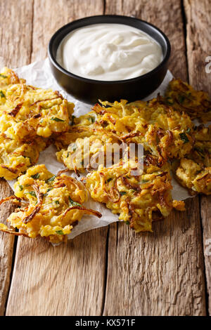 Bhajis oignon croustillant snack vegan ou entrée avec du yogourt sur la table. La verticale Banque D'Images