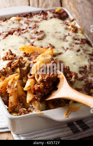 Crockpot de millions de dollars des pâtes avec du fromage et de la viande bovine close-up dans un plat allant au four, sur une table verticale. Banque D'Images