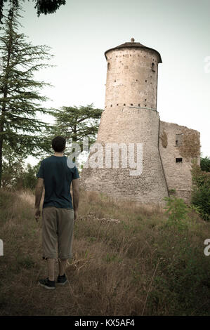 L'homme l'observation d'une vieille forteresse en face de lui, comme une sorte de défi. Château italien, placé en Émilie-Romagne. Banque D'Images