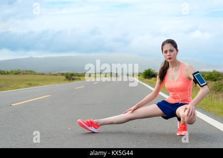 Assez confiant joueur marathon man sur une jambe sur la posture pour réchauffer le corps et préparé l'exécution de la formation d'entraînement de l'endurance. Banque D'Images