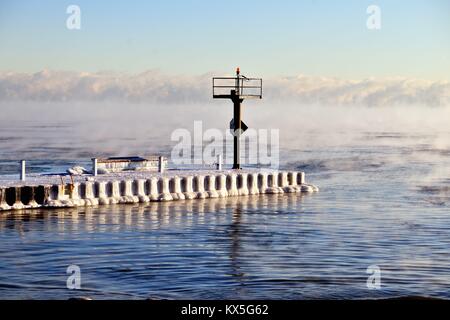 La glace se forme sur un brise-lames que de la vapeur s'élève des eaux du lac Michigan que la glace se forme dans le Chicago's 31st Street Port. Chicago, Illinois, USA. Banque D'Images