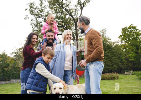 Grande famille heureuse avec le labrador chien passer du temps ensemble dans le parc Banque D'Images