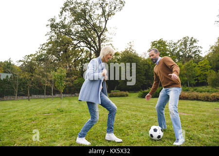Mature Woman playing soccer outdoors Banque D'Images