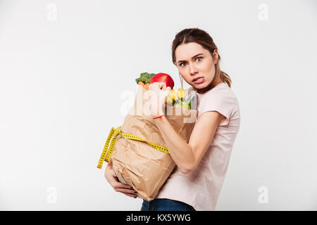 Portrait d'un homme avare girl holding bag avec des provisions plus isolé sur fond blanc Banque D'Images