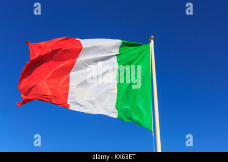 Le drapeau national italien sur un poteau contre clair ciel bleu profond Banque D'Images