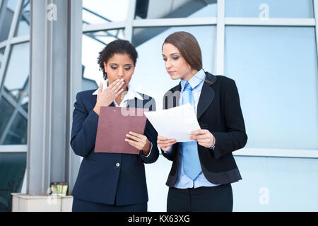 Two businesswomen working together with paperwork in hands Banque D'Images