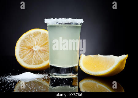 Coup du verre avec un citron sur fond noir Banque D'Images