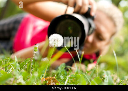 Photo de sexe féminin avec l'appareil photo de prendre une photo de la fleur Banque D'Images