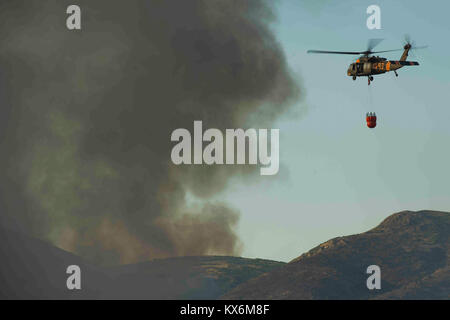 Détachement de la Garde nationale de l'Utah 2, l'entreprise C, 1er Bataillon de l'aviation d'appui général, 171e Régiment d'aviation de West Jordan, Utah, remplir d'eau gouttes avec un 'Bambi' godet sur une forêt sur le Centre de formation de l'Utah, Utah, Camp Williams 6 août 2012. Bambi seaux sont marqués d'un nom pour réservoirs d'eau Les godets faits par SEI Industries, une société canadienne. Ils peuvent déverser de 660 gallons d'eau sur un feu à la fois. (U.S. Air Force photo de Tech. Le Sgt. Dennis J. Henry Jr./libérés) Banque D'Images