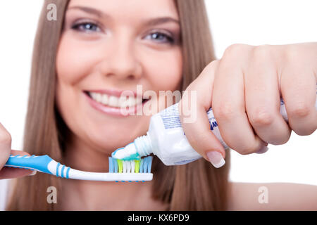 Jeune femme avec brosse à dents et pâte, hygiène dentaire, isolé sur fond blanc Banque D'Images