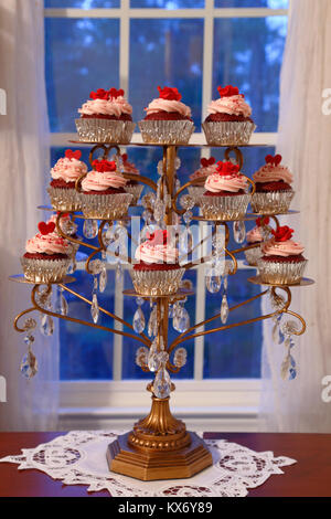 Cupcakes. Red Velvet cupcakes affichée sur un chandelier en face d'une fenêtre Banque D'Images