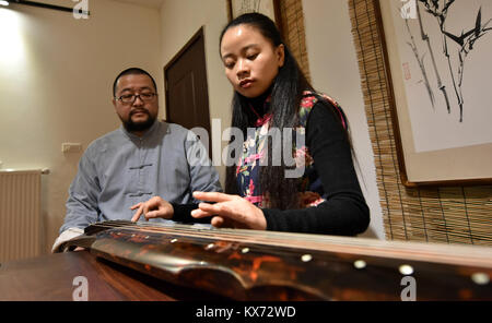 (180108) -- ZUNYI, Janvier 8, 2018 (Xinhua) -- Wang Bing et son épouse Fu Min tester un nouveau fait de guqin Zunyi, au sud-ouest de la province du Guizhou, en Chine, le 7 janvier 2018. Le Guqin chinois, ou cithare chinoise, a une histoire de plus de 3 000 ans et c'est un représentant de la musique chinoise de la tradition. Wang Bing, l'apprentissage de la compétence de guqin à partir de 10 ans, a fait de guqin depuis plus de 30 ans. Il faut plus de 100 procédures de façon parfaite, Guqin selon Wang, l'héritier de prendre des décisions en Guqin Zunyi Ville. Le Guqin faites par Wang est aimé par les fans à la maison et à l'étranger. Guqin et ses mus Banque D'Images