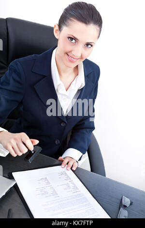 Smiling business woman ou secrétaire de mettre sur un document de timbres Banque D'Images