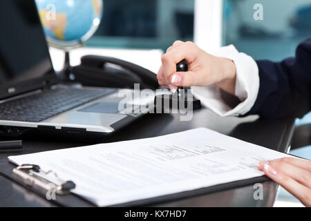 Les femmes part mettre tampon sur un document, Close up Banque D'Images