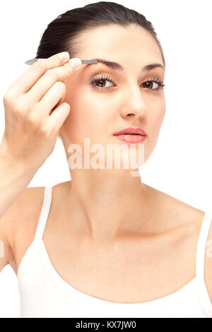 Fille tire eyebrow brucelles, Close up, isolated on white Banque D'Images
