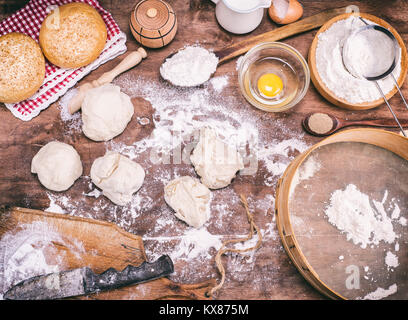 Morceaux de pâte faite de farine de froment sur une table marron et ingrédients Banque D'Images