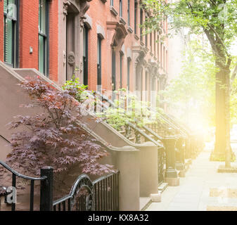 Le tranquille quartier historique du trottoir de la rue bordée de bâtiments en grès brun dans un quartier de Greenwich Village à Manhattan New York NYC Banque D'Images
