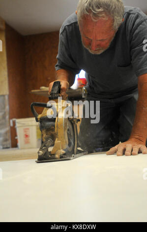 La galène, AK - United Methodist Bill Smith, bénévole de Washougal, Washington, utilise une Skilsaw pour couper des matériaux dosseret pour réparer la douche d'inondation au printemps Paddy survivant Nollner. Alaska a subi de graves inondations le long de la rivière Yukon en mai et juin après un hiver plus long que la normale et rapide des températures. Un embâcle sur la rivière s'est produit près de la galène qui ont provoqué des inondations et des dommages à grande échelle par de l'eau élevé et de grandes plaques de glace. État, locaux et fédéraux, les organismes bénévoles continuent de donner la priorité à la réparation d'un refuge pour réduire le besoin d'abri d'hiver. - En Gal Banque D'Images