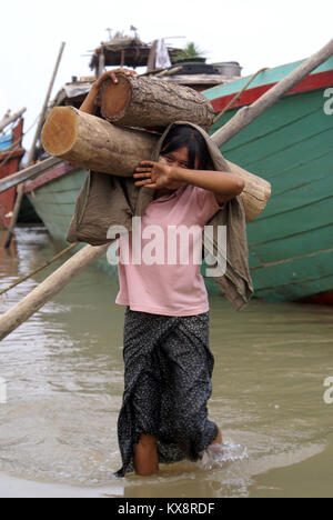 Jeune fille transporter le bois dans la rivière, Mandalay, Myanmar Banque D'Images