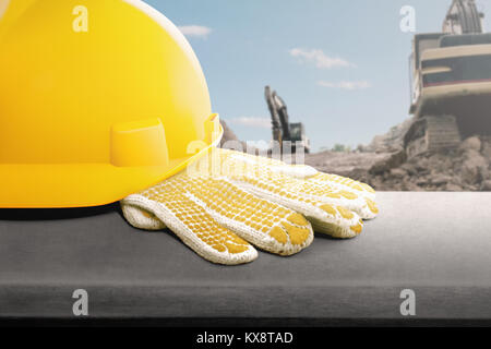 Casque jaune et des gants sur le bureau at construction site Banque D'Images