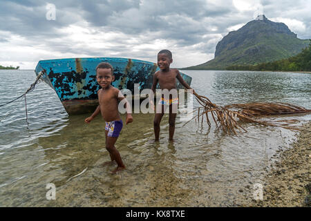 Spielende Kinder vor dem Berg Le Morne Brabant, Rivière Noire, Ile Maurice, Afrika | Les enfants jouant sur la plage, péninsule Le Morne, Rivière Noire, Mauritiu Banque D'Images