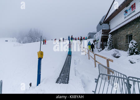 Skier sur une bande téléski sur le chemin de la deuxième étape d'un télésiège réunissant les touristes à la sommet de Skrzyczne mountain à Szczyrk, Pologne Banque D'Images