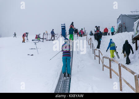 Skier sur une bande téléski sur le chemin de la deuxième étape d'un télésiège réunissant les touristes à la sommet de Skrzyczne mountain à Szczyrk, Pologne Banque D'Images