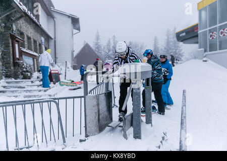 Skieurs et planchistes passer par tourniquets tripodes portes sur la montagne Skrzyczne à Szczyrk en Pologne Banque D'Images