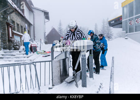 Skieurs et planchistes passer par tourniquets tripodes portes sur la montagne Skrzyczne à Szczyrk en Pologne Banque D'Images