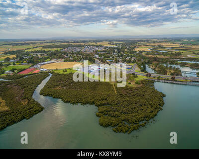 Vue aérienne de mangroves et de petite ville côtière en Australie au coucher du soleil Banque D'Images