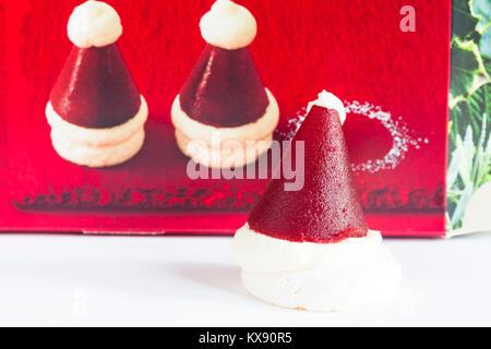 M&S mini Santa hats - base de meringue croustillante garnie de crème vanille et gelée de framboise Banque D'Images