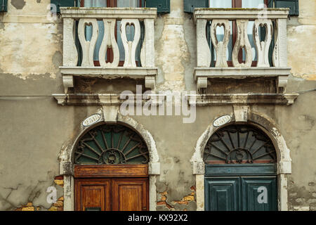 Porte et fenêtres à volets construction le long d'un petit canal en Vénétie, Venise, Italie, Europe. Banque D'Images