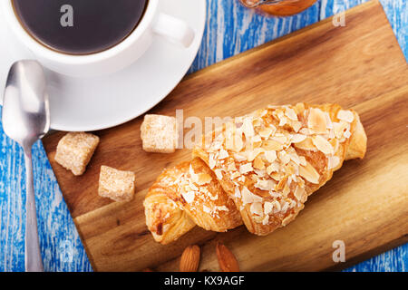 Délicieux petit déjeuner nutritif de café noir avec des croissants dans les flocons d'amandes Banque D'Images